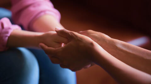 Women holding hands.