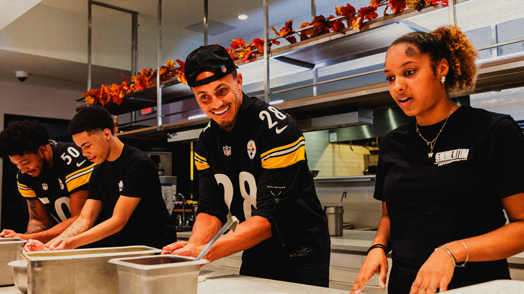 Teenagers smiling and working together in a restaurant kitchen
