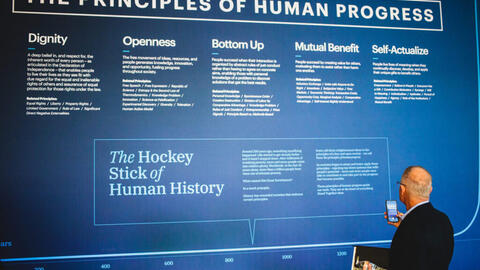 A man looking at an event exhibit articulating the principles of human progress