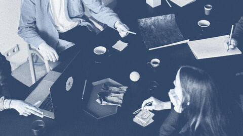 People sitting around a table collaborating with one another.