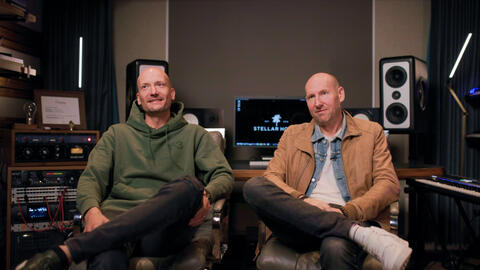 Two men sitting in a music studio.