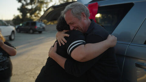 Mike Rowe embracing Lenzy Phillips after gifting her a car.