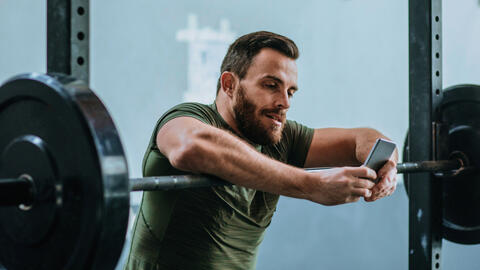 A person on their phone while at the gym.