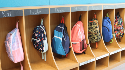 School backpacks hanging in cubbies