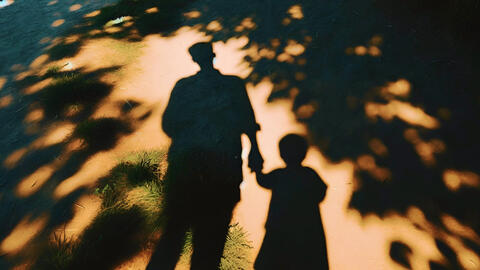 Parent holding their child's hand.