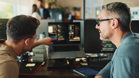 Two tech workers working together.