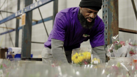 1-800-Flowers employee packaging flowers.