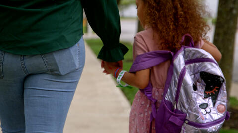 Child holding hands with her mother/mentor