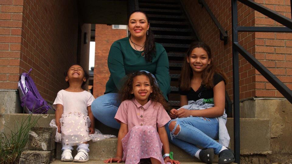 Mother and three children sitting on steps