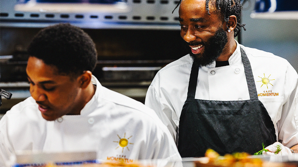 Two smiling young men in a commercial kitchen