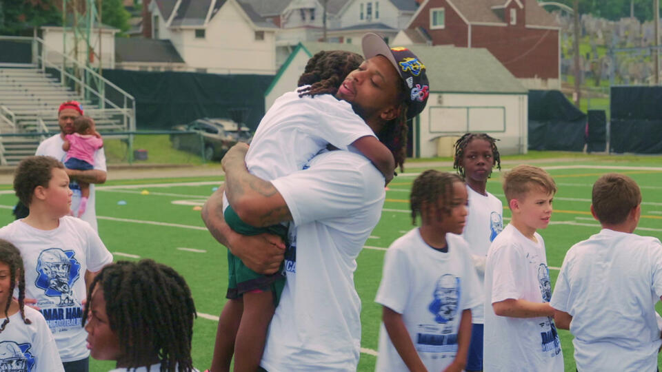 Damar Hamlin on the field with children.