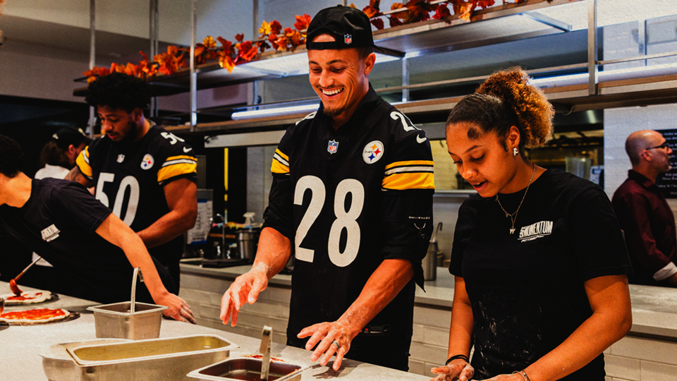 NFL Players Working in a Kitchen
