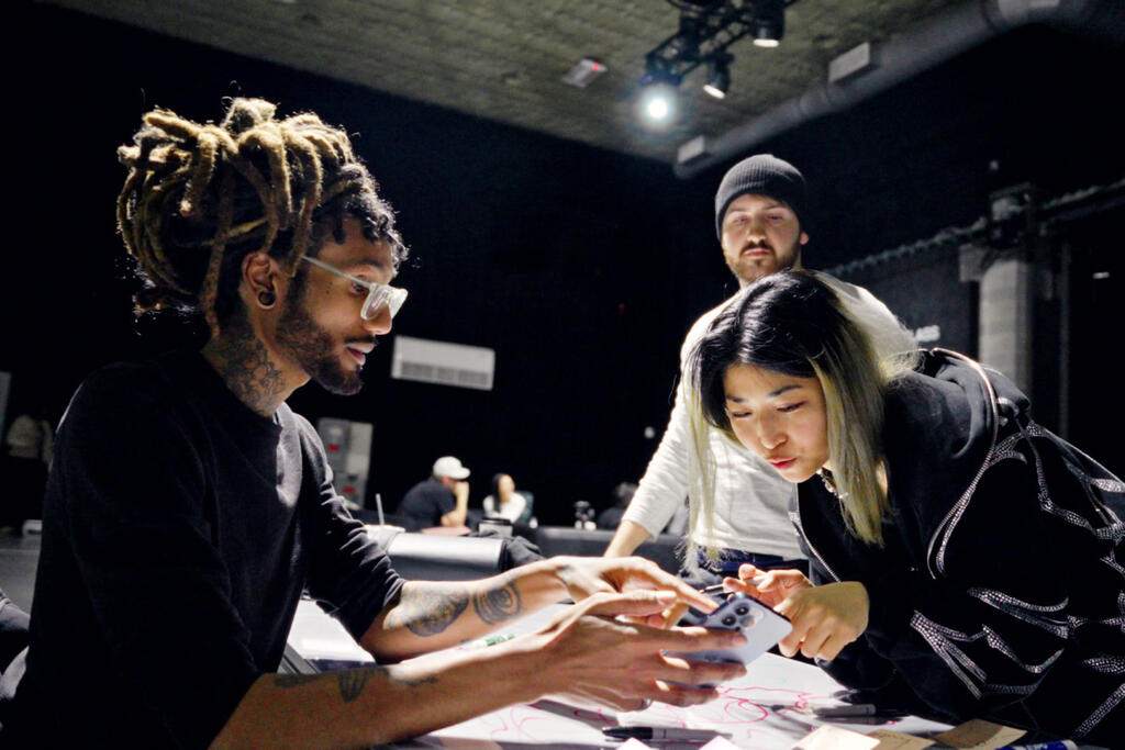 A group of workers looking at a phone.