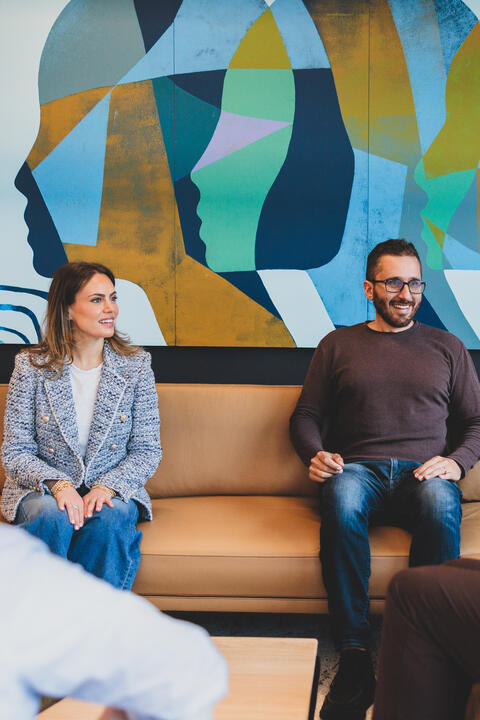 Two people seated and smiling at Stand Together HQ